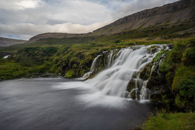 Scenic view of waterfall against sky