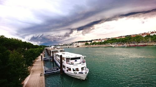 Boat in sea against cloudy sky