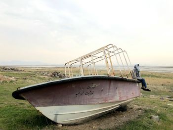 Abandoned ship on beach against sky