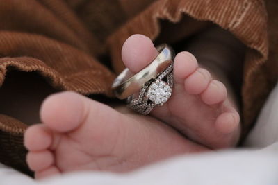 Close-up of newborn baby with rings on toes