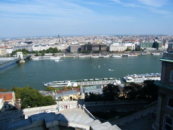 High angle view of buildings by river against sky