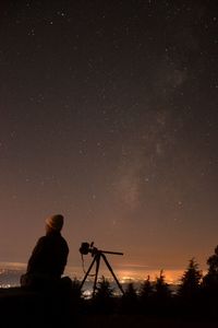 Man standing against star field at night