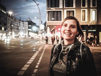 Portrait of young woman on city street at roadside