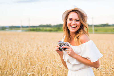 Portrait of a smiling young woman standing in farm