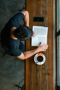 High angle view of boy playing with coffee on table