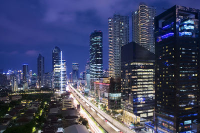 Illuminated buildings in city against sky at night