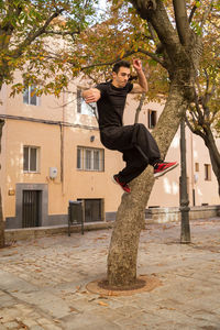 Young man jumping against trees