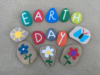 High angle view of colorful text on pebbles at sandy beach