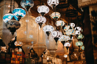 Low angle view of illuminated lanterns hanging in store