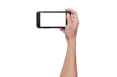 Cropped hand holding smart phone against white background