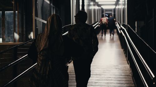 Rear view of people walking on staircase