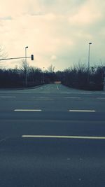 Empty road with trees in background