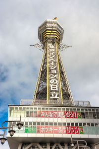 Low angle view of communications tower against cloudy sky