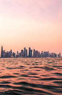 Modern buildings in city against sky during sunset