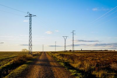 Road amidst field against sky