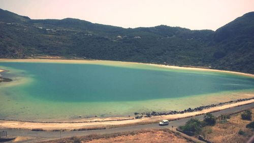 High angle view of lake and mountains against sky