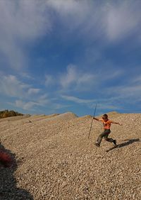 Man skateboarding on land against sky