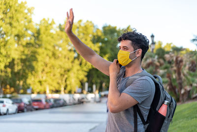 Young latin man with face mask using phone