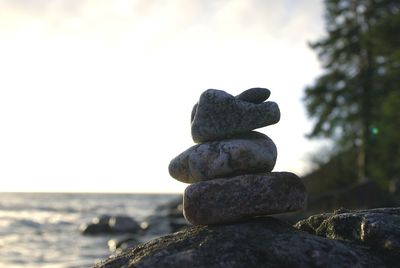 Stack of stones on beach against sky