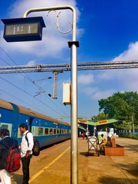 Rear view of people on train against sky