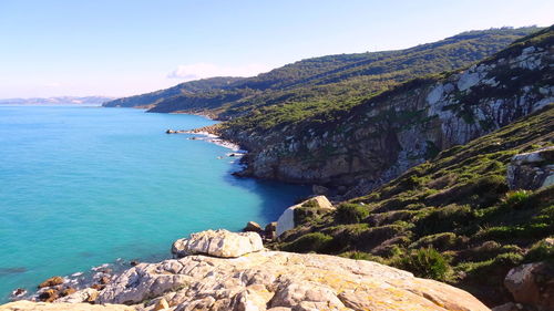 Scenic view of sea and mountains against sky