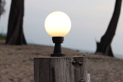 Close-up of wooden post at sunset