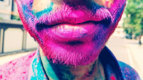 Midsection of man with powder paint on face during holi