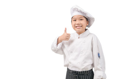 Portrait of smiling girl standing against white background