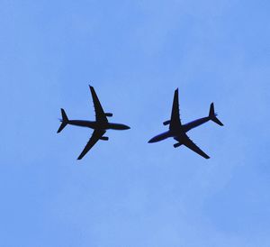 Low angle view of airplane against clear blue sky