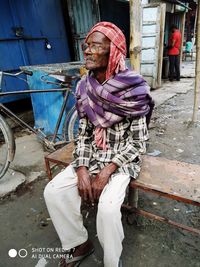 Midsection of woman sitting on street in city