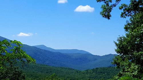 Scenic view of mountains against blue sky