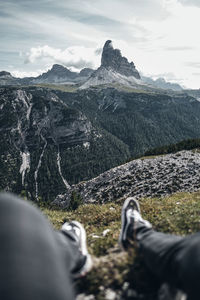 Low section of people on mountain against sky