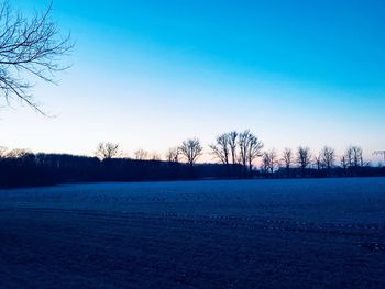 Scenic view of snowy field against sky during winter