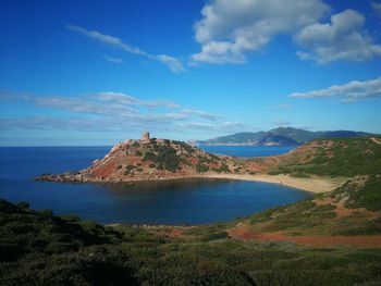 Scenic view of sea and mountains against blue sky