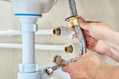 Cropped hand of person repairing faucet