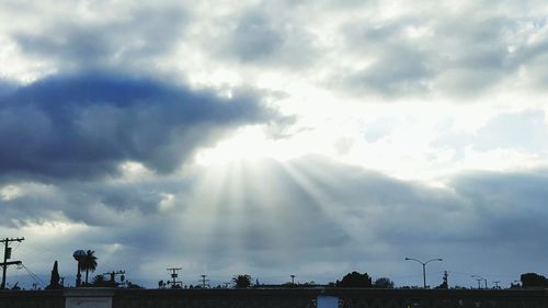 Silhouette of trees against cloudy sky