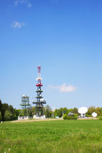 Windmill on field against clear blue sky