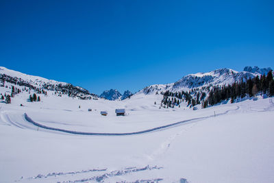 Scenic view of snowcapped mountains against clear blue sky