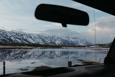 View of the grand teton mountain range and a flooded ranch from car