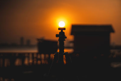 Close-up of illuminated lamp on table against sky during sunset