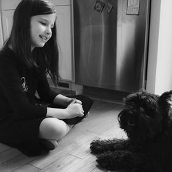 Close-up of woman with dog sitting on floor at home