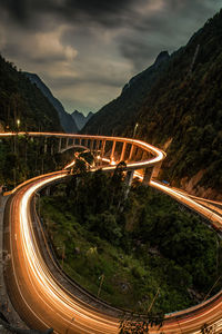 Light trails on road against sky at night