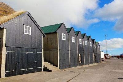 Row of houses on beach by buildings against sky