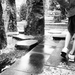 Low section of woman standing on footpath