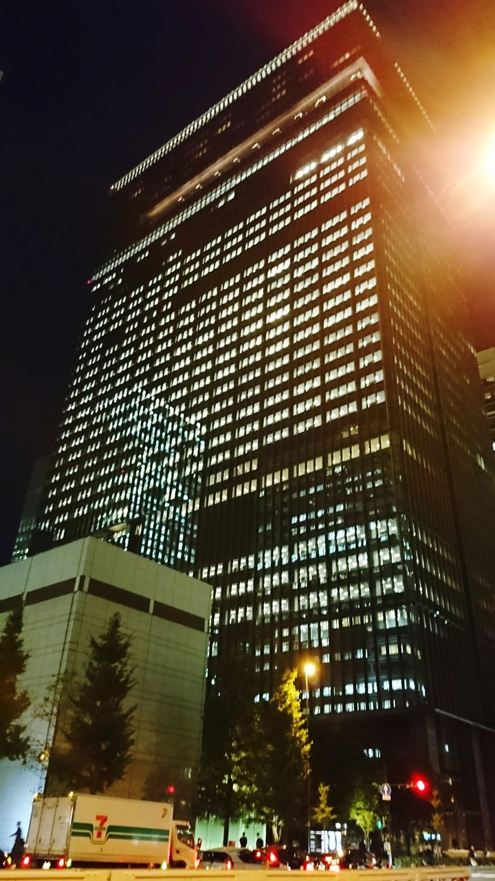 illuminated, low angle view, built structure, night, architecture, building exterior, outdoors, modern, skyscraper, no people, sky, city, tree