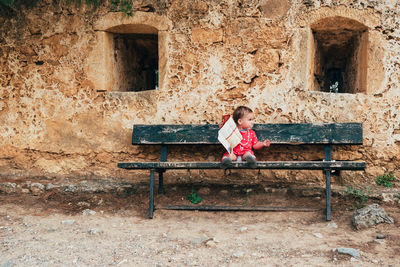 Full length of girl sitting on bench