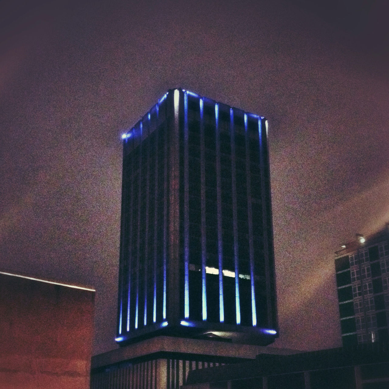 LOW ANGLE VIEW OF MODERN BUILDING AT NIGHT