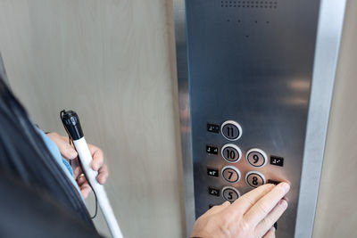 Person with white cane using elevator