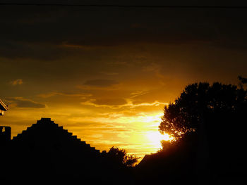 Low angle view of silhouette trees against sky at sunset