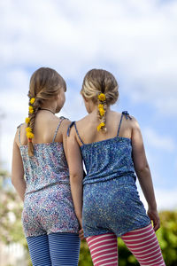 Two girls with dandelion flowers in braids